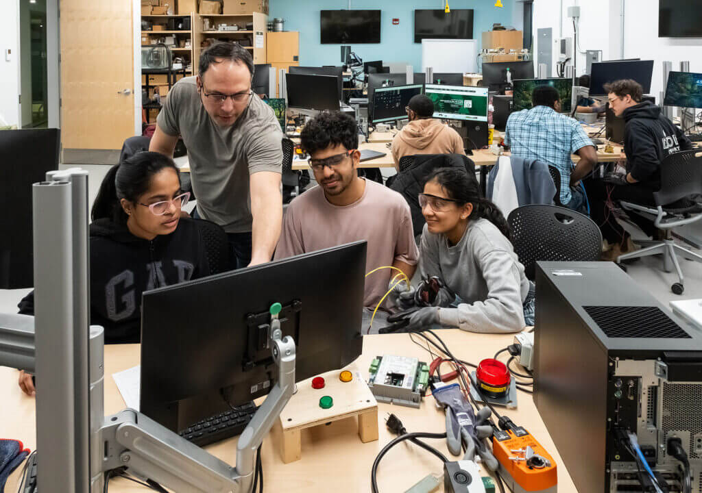 Students working on a computer screen testing equipment