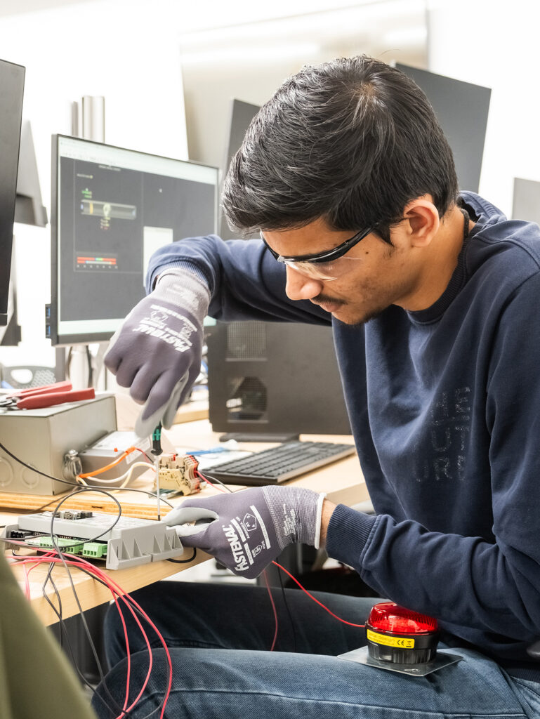 Student using a screwdriver to install wiring