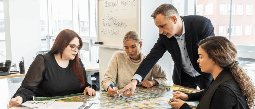 A group of people analyze a map on a table.