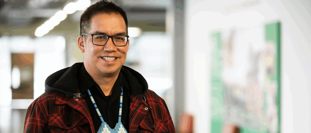 An Indigenous student wearing a large blue beaded medallion.