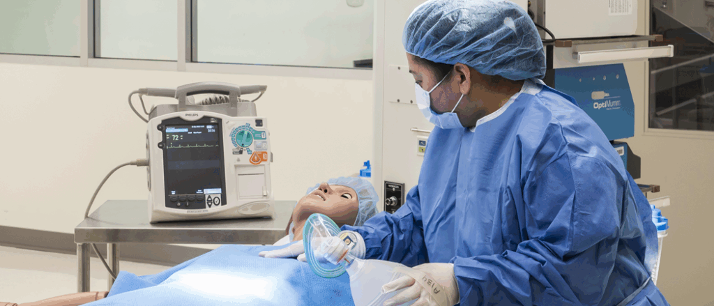 A nursing student practices with a manikin.