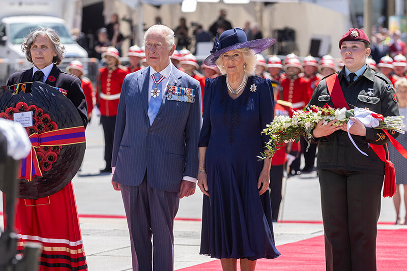 Warrant Officer Olivia Vernelli stands next to Their Majesties King Charles III and Queen Camilla at the National War Museum.