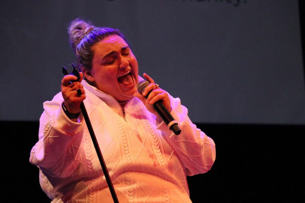 Jamie Fine sings on stage next at the Alumni of Distinction Awards Night 2024.