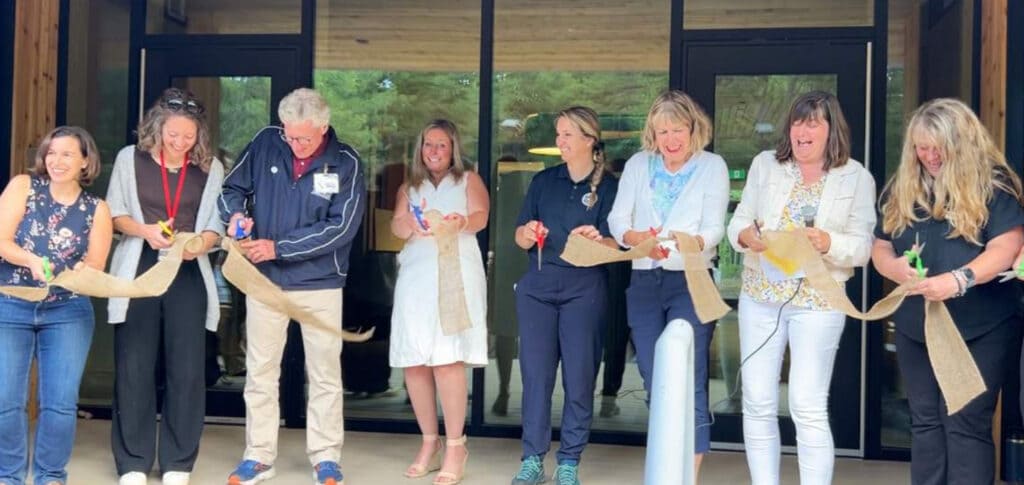 A group of people cut a ceremonial ribbon.