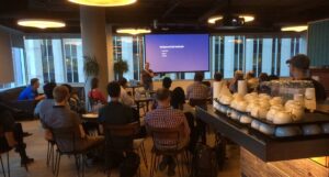 A group of programmers watch a presentation by an expert.