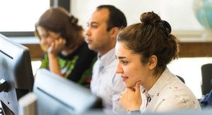 female and male students looking at monitors