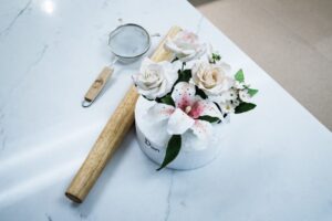 A white cake with a floral arrangement, resting on a light granite countertop