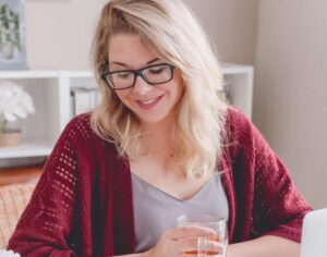 Female Event Management student reading at home while drinking a tea