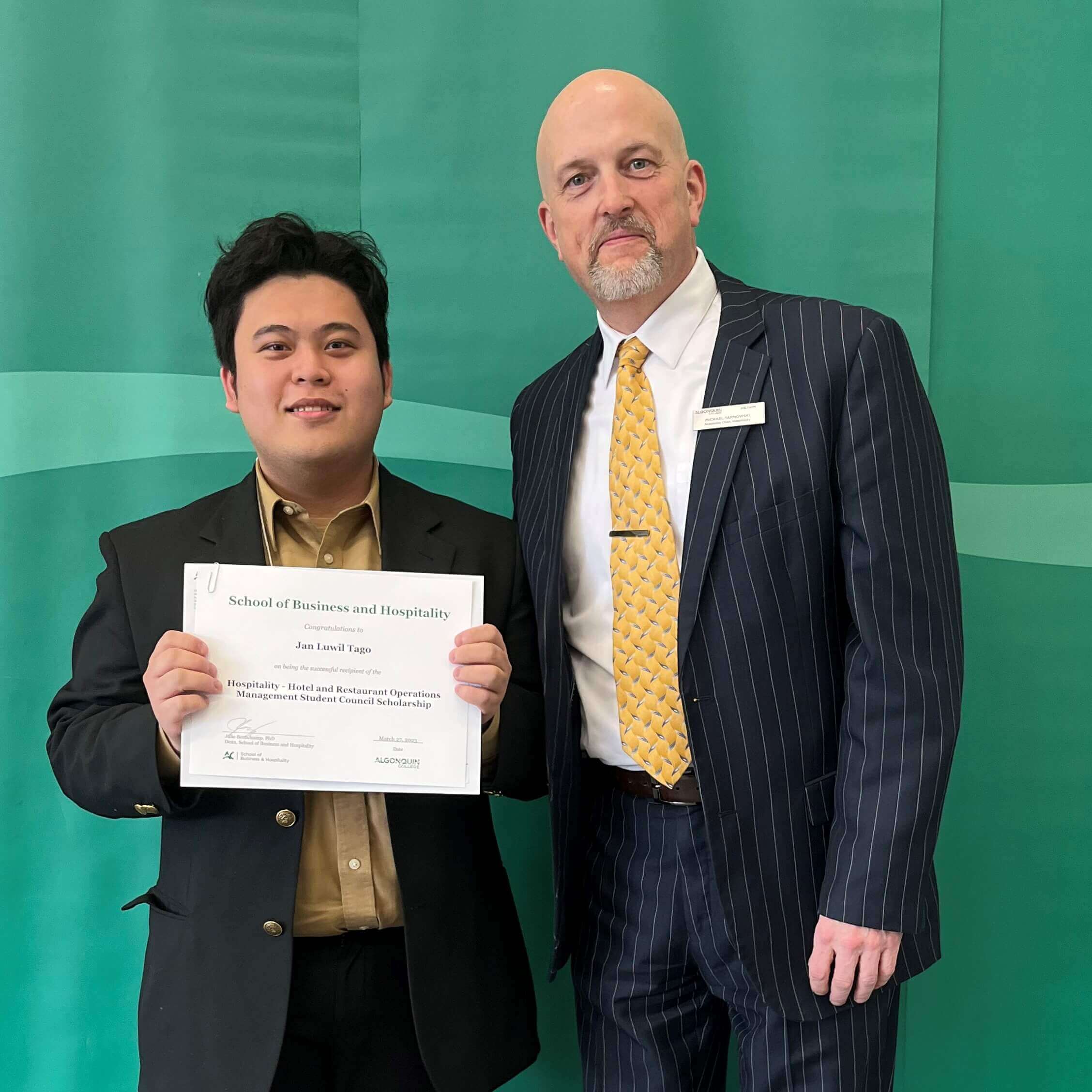 Student Jan Luwil Tago, Recipient of the Hospitality - Hotel and Restaurant Operations Management Student Council Scholarship, with professor