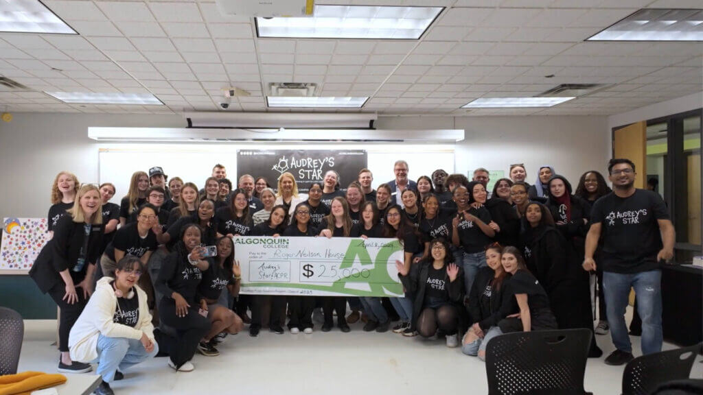 Group of PR students posing with the cheque from their successful fundraising initiative