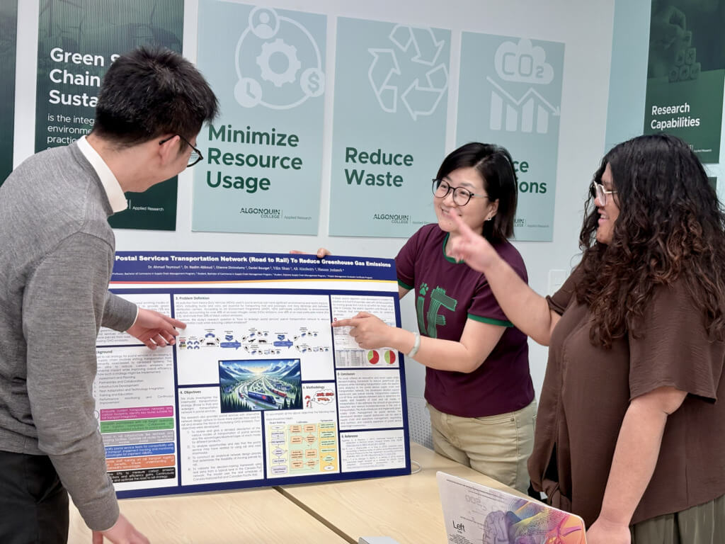 three students explaining sustainability project board