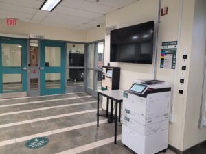 An image of a Ricoh multi function printer located on the first floor of Residence near the Residence Life office.