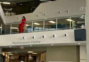 Anita Tenasco hangs red dressed in the E Building.