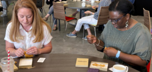 Two employees create medicine pouches during an event in Nawapon