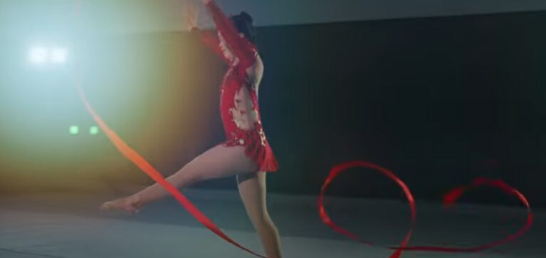 Action shot of Kimana Mar performing her rhythmic gymnastics routine