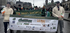 Students Brandon Ross and Nolan Tarantino walking in the parade. (Note- City of Ottawa Mayor Mark Sutcliffe walking directly behind them.) 
