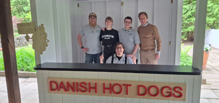 Cabinetmaking students pictured with their Program Coordinator John McKinlay-Key, inside the completed hotdog stand.