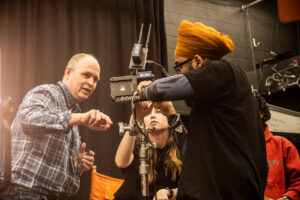 Professor showing student something on a film camera