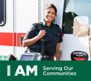 Paramedic student smiling, while leaning against a Paramedic Van