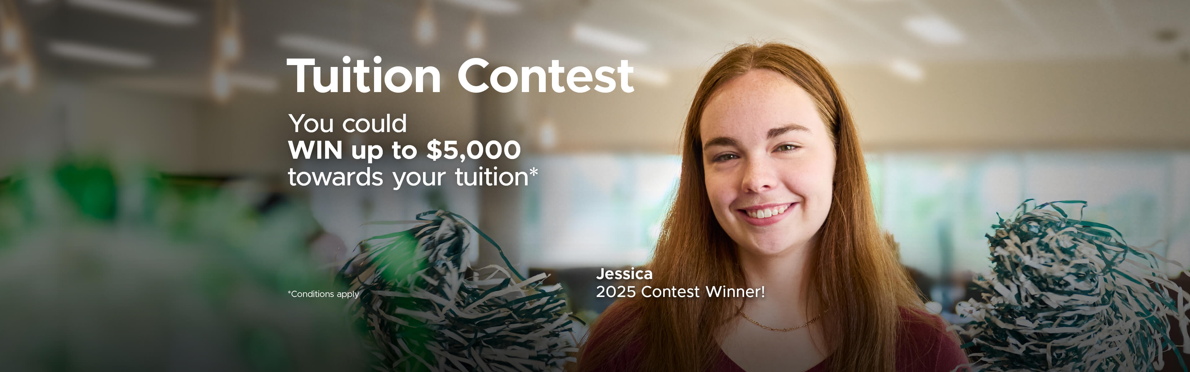 female student smiles at camera waving green pom poms