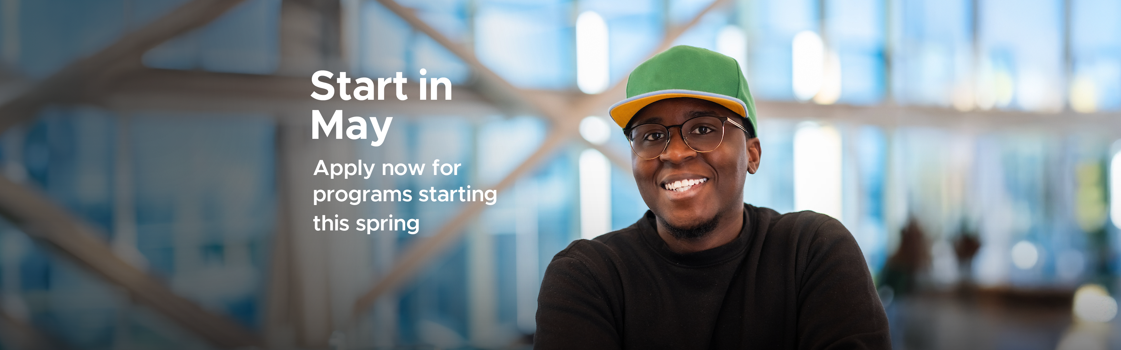 Male student with green hat smiling at camera.