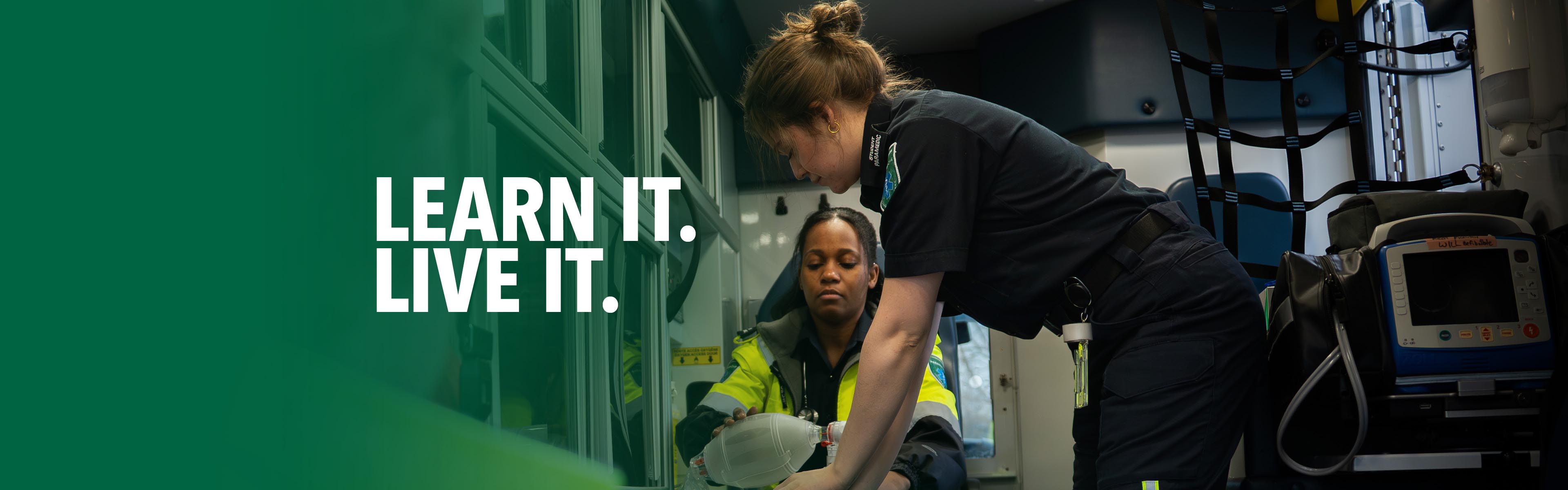 Paramedic students practising emergency patient care with medical equipment inside an ambulance during hands-on training.