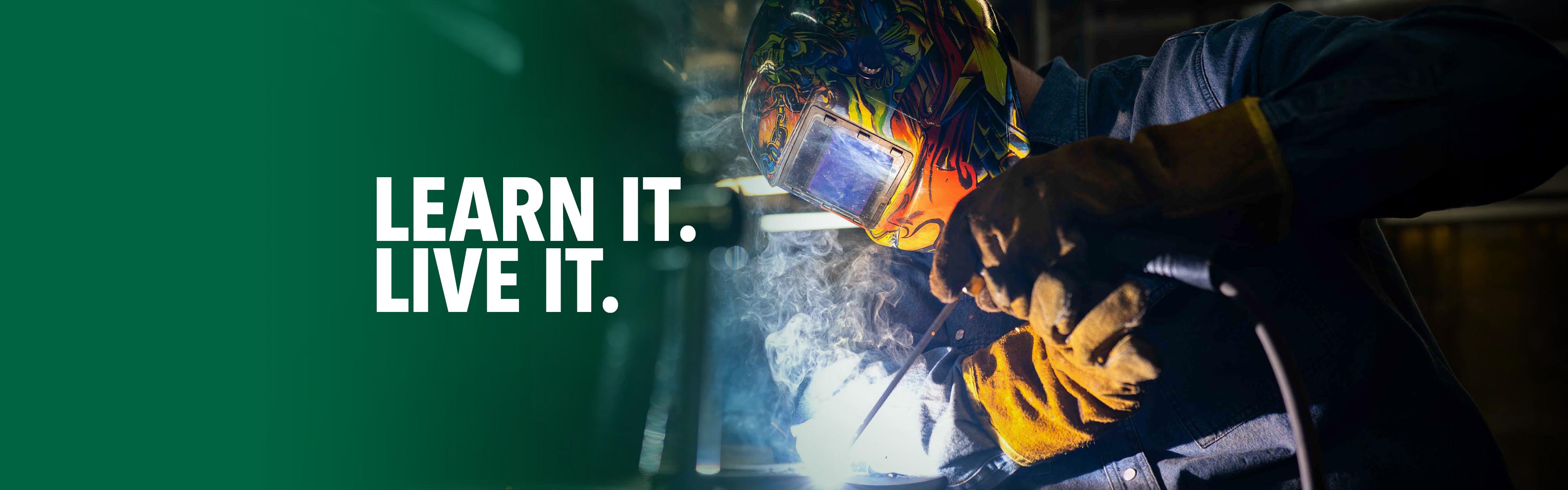 Welding student wearing protective equipment while welding metal during hands-on skilled trades training.