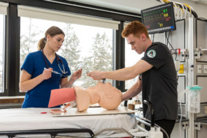 respiratory therapy students practicing their skills with a mannequin in the respiratory therapy lab