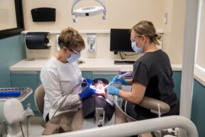 two professors demonstrating dental assisting skills on a mannequin head