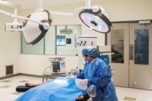 Registered nurse in an operating room on campus working with a mannequin