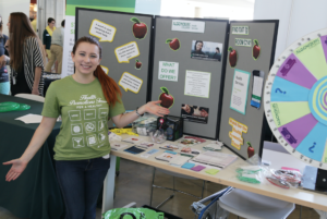 Health promotion representative staffing a booth with informational materials