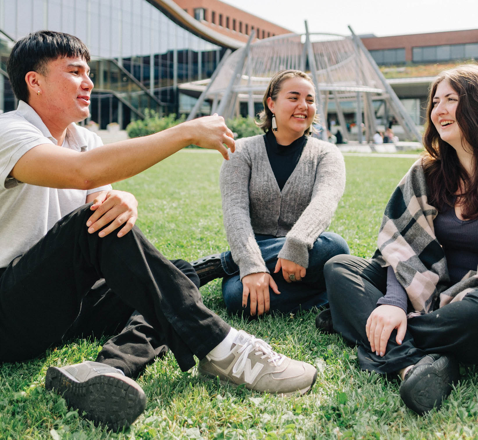 Three people are sitting on the grass, engaged in conversation. AI generated content
