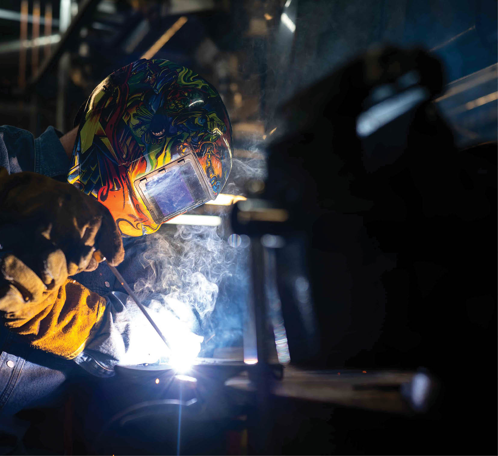A man wearing a helmet and safety gear is welding a metal piece. AI generated content