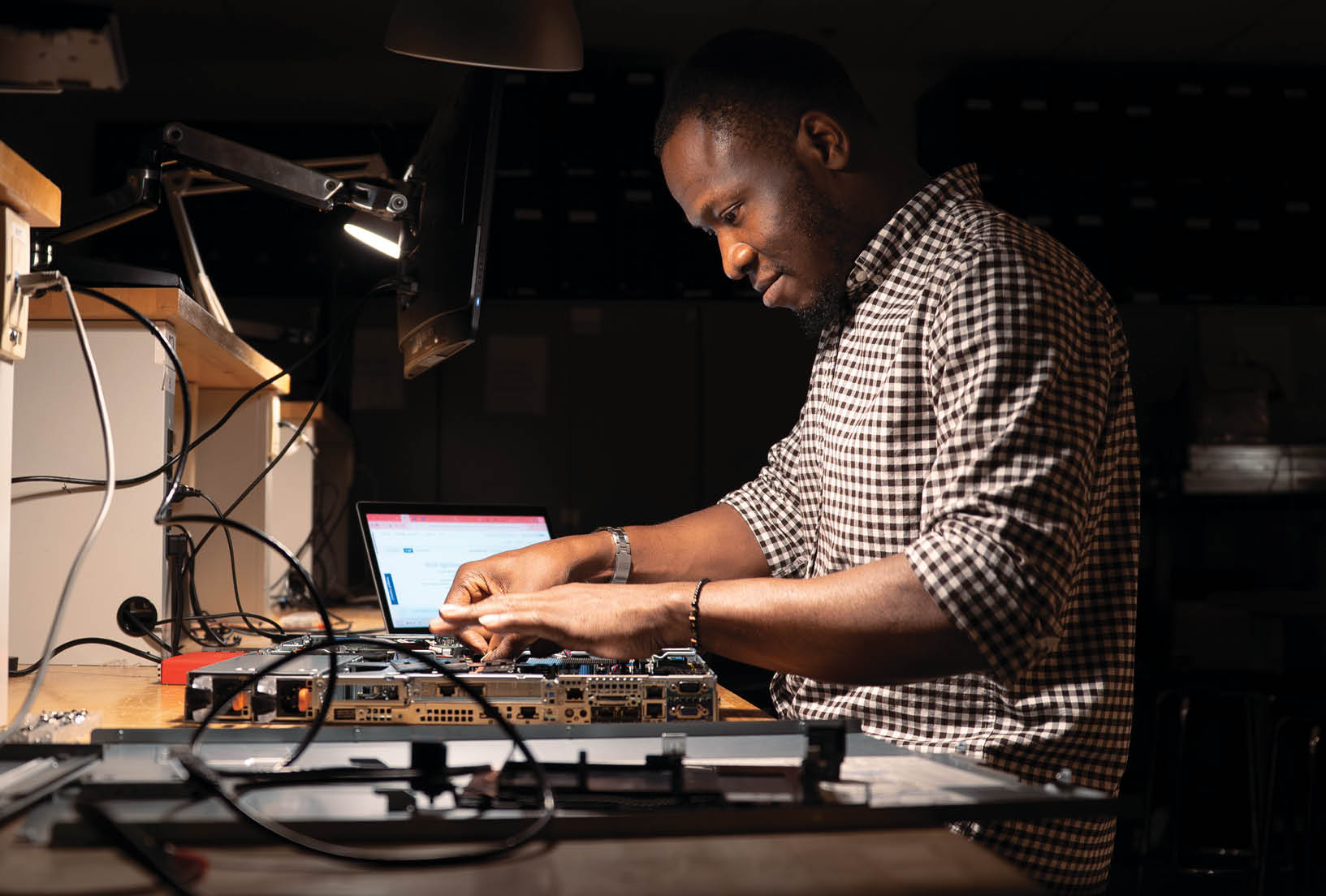 A man is sitting at a desk, working on a laptop. AI generated content
