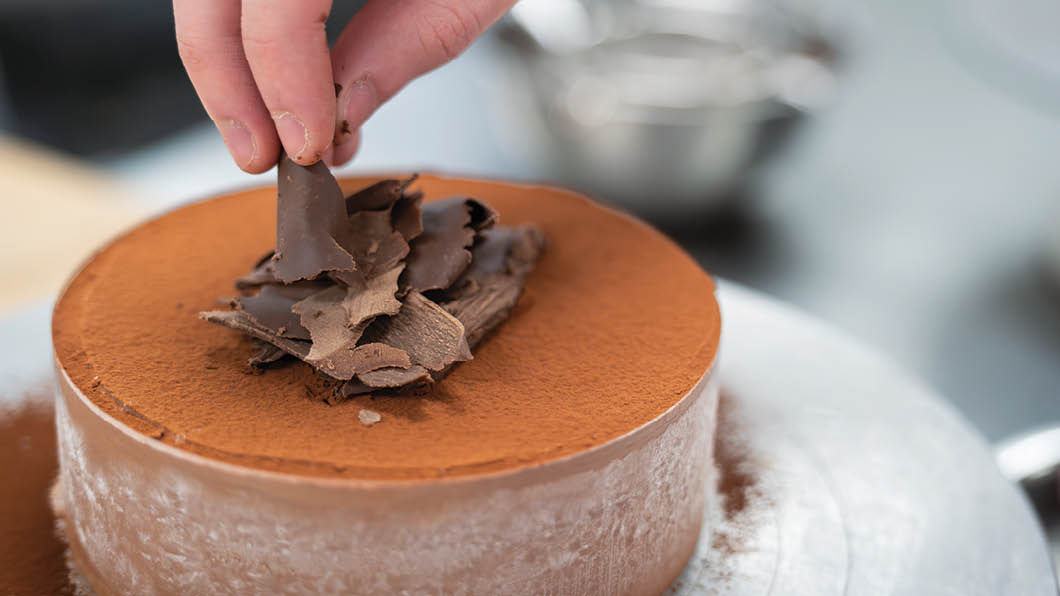 A person is decorating a cake with chocolate. AI generated content
