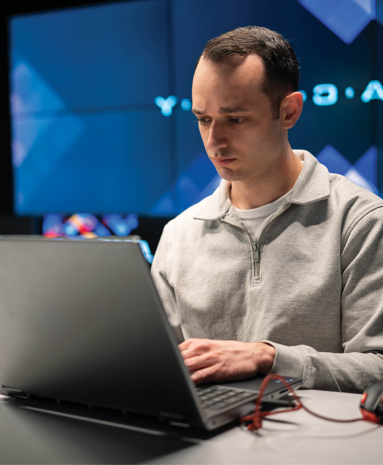 A man is sitting at a desk using a laptop. AI generated content