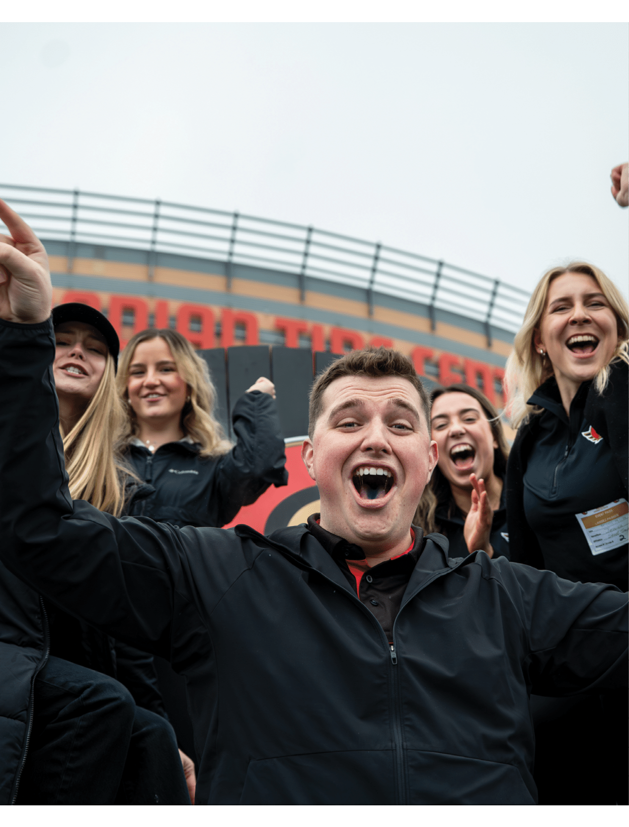 A group of people are standing in front of a stadium, posing for a picture. AI generated content