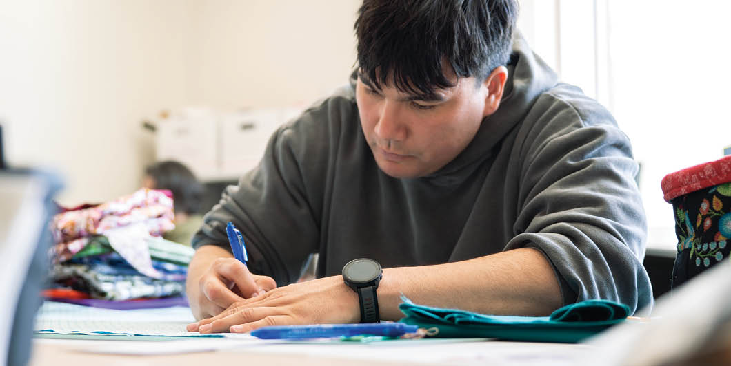 A man is writing on a piece of paper at a table. AI generated content
