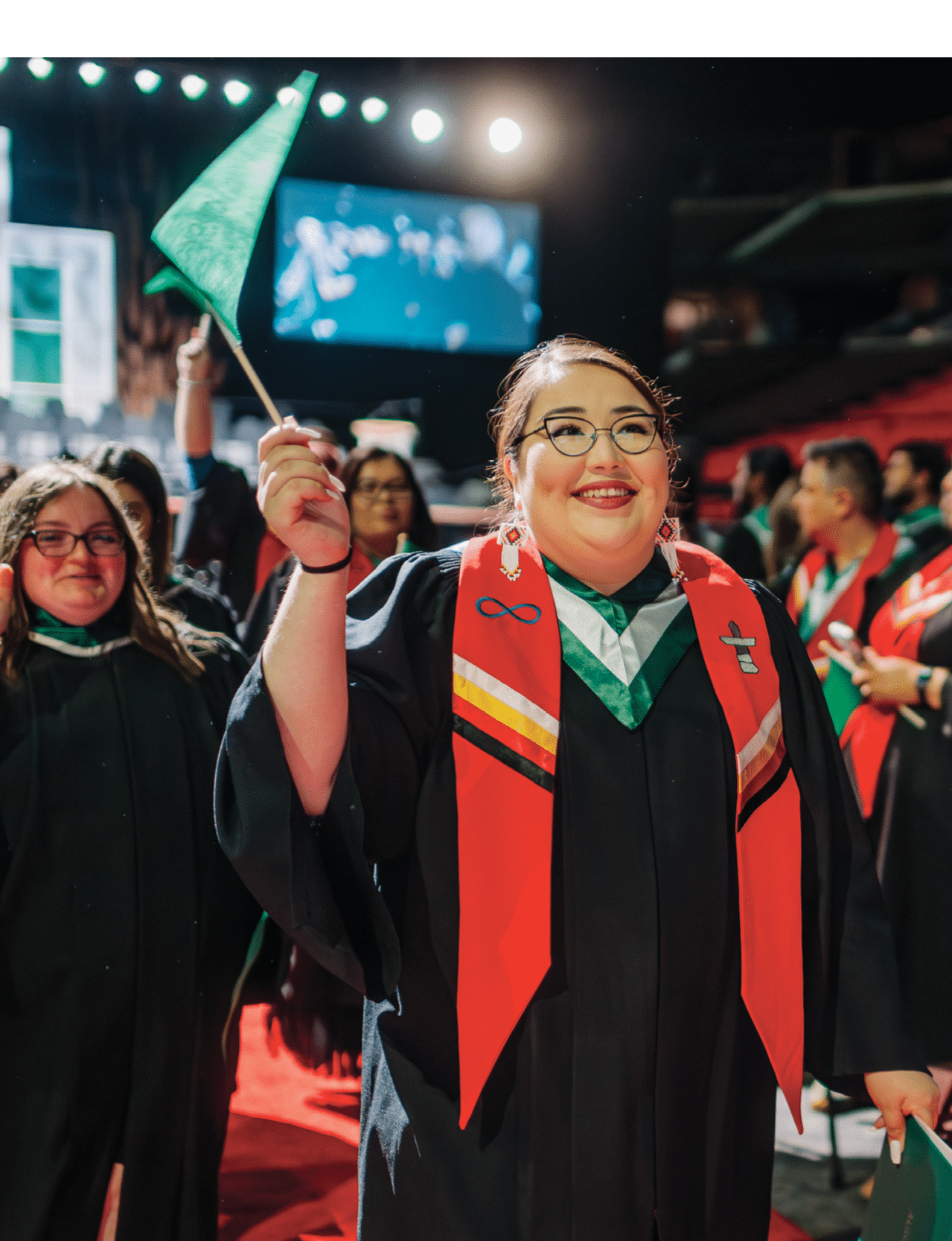 A group of people wearing graduation robes and smiling. Description generated by AI