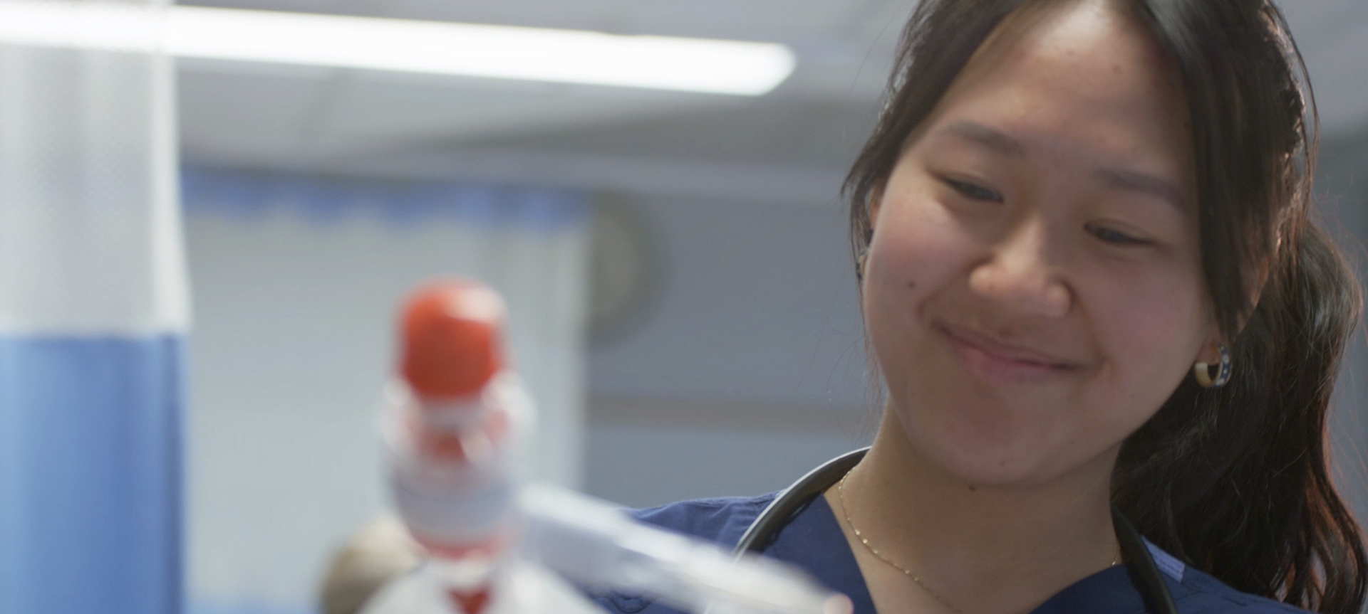 student in medical attire preparing IV