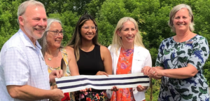 Claude holds wampum belt with leadership from Pembroke outside at medicine wheel dedication