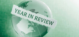 Image of a globe with the words year in review circling the globe on a green background