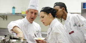 Culinary Skills instructor guiding two students at the culinary lab.