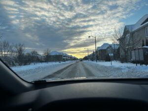 Snow-covered residential street in Ottawa at sunset.
