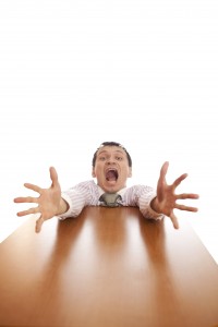 Man reaching over a desk for help on career objective statements for resumes.