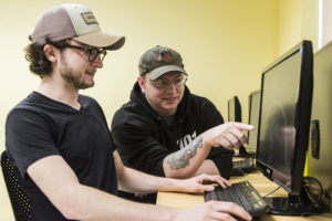 two students looking at a computer monitor