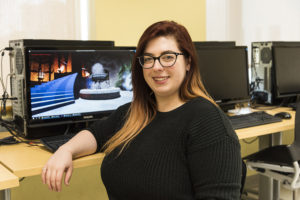 student with computer showing game being designed