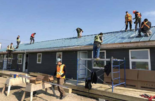Workers preparing for solar panel installation in Nisichawayashik