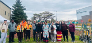 group posing next to planting of Tiny Forest project