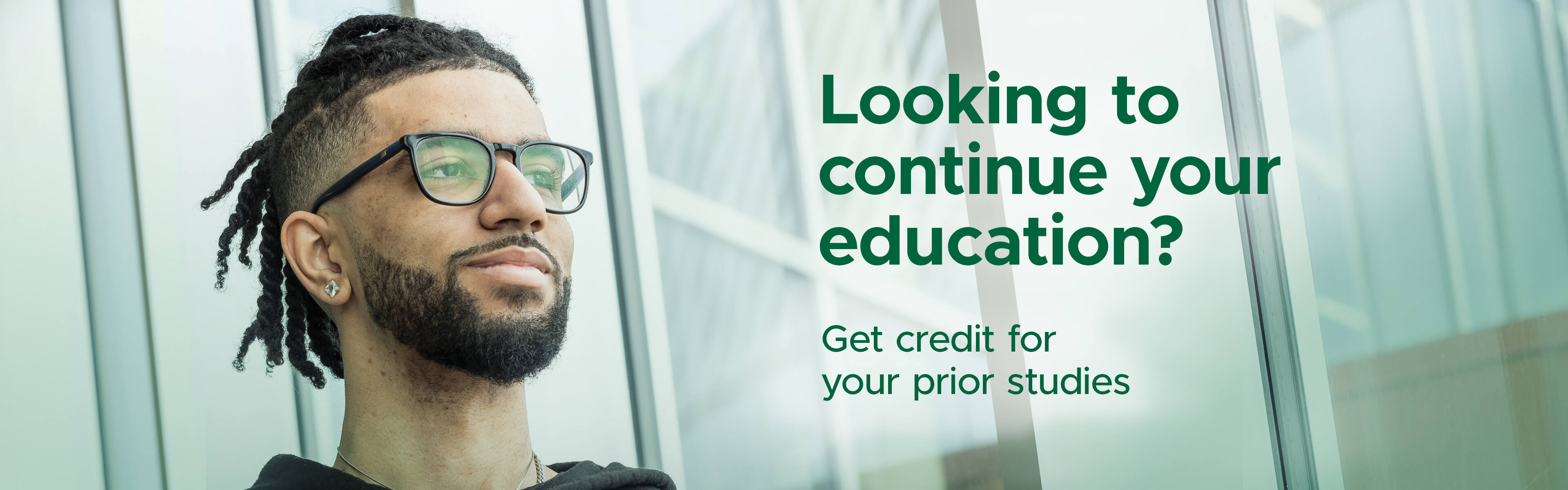 Male student with glasses looking into the distance.